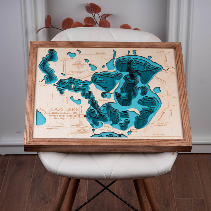 Admire the craftsmanship of the 3D Wooden Cass Lake Map displayed on a chair, a unique piece of Cass Lake Wooden Map Wall Art by Moc Tho